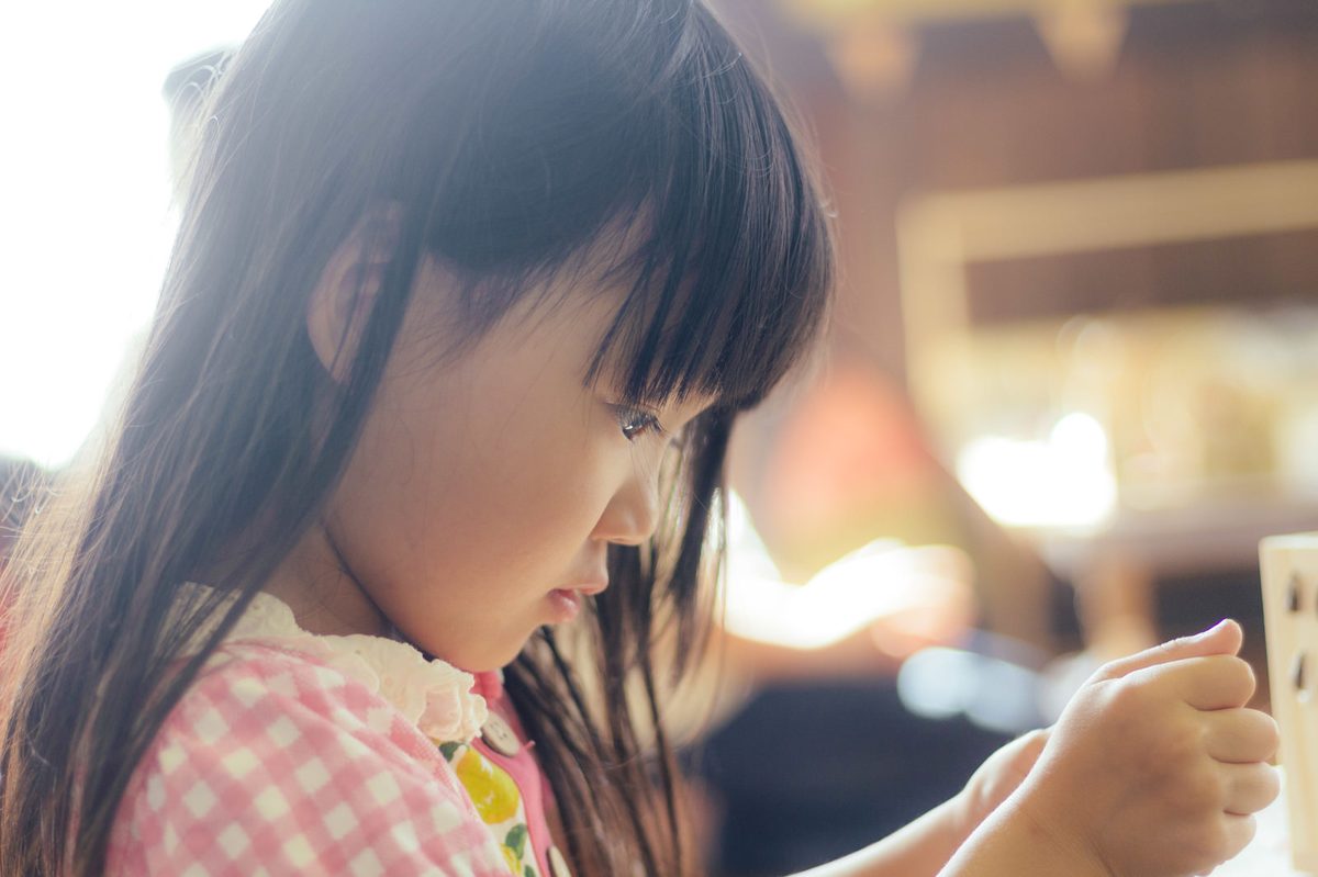 机に向かって、集中して文字を書いている子ども